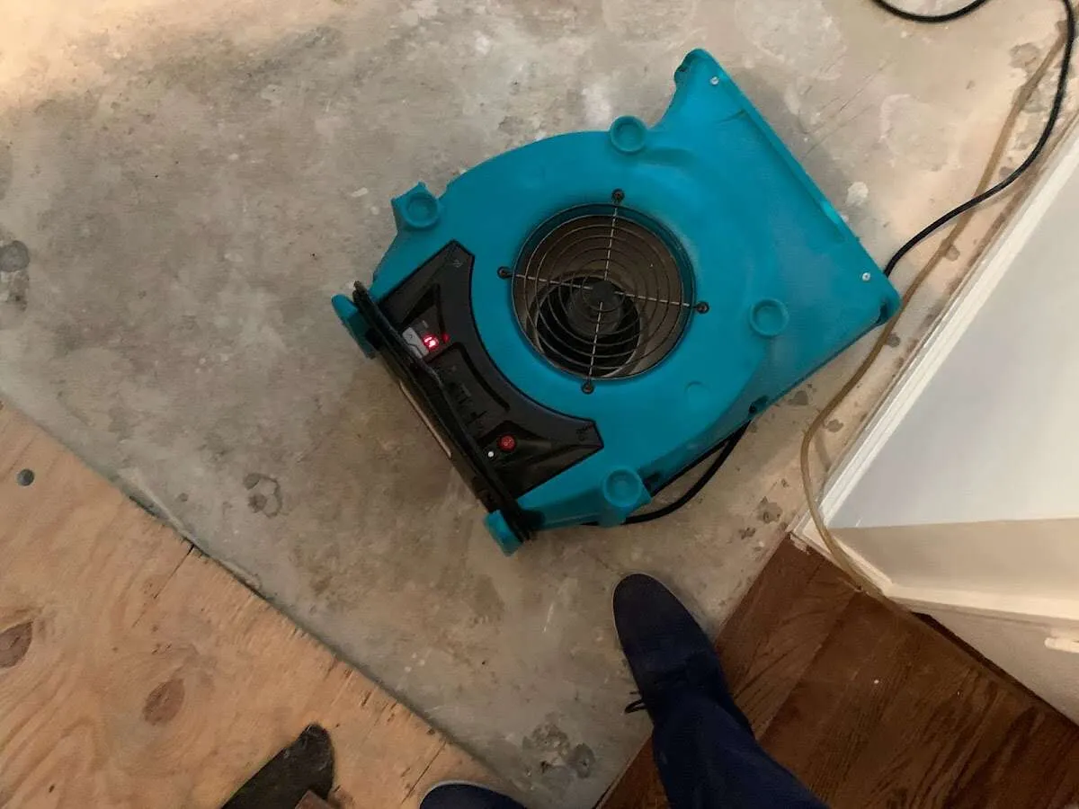 Air mover drying subfloor during Leak Detection & Repair in East Caln
